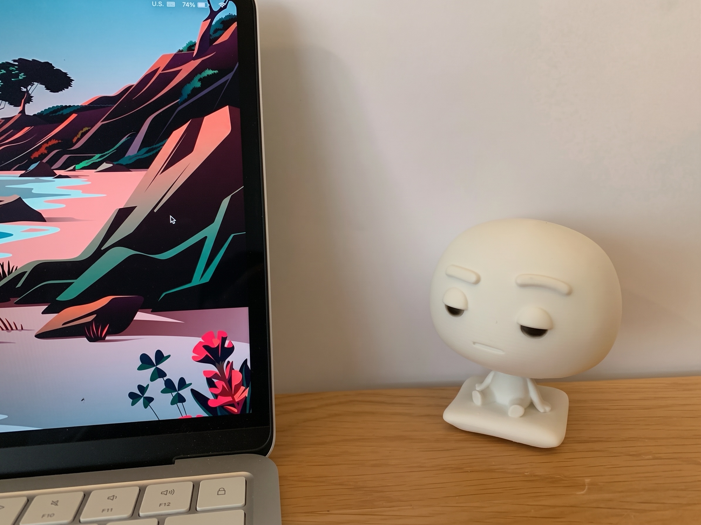Pixl Nub sitting beside a MacBook on a wooden desk