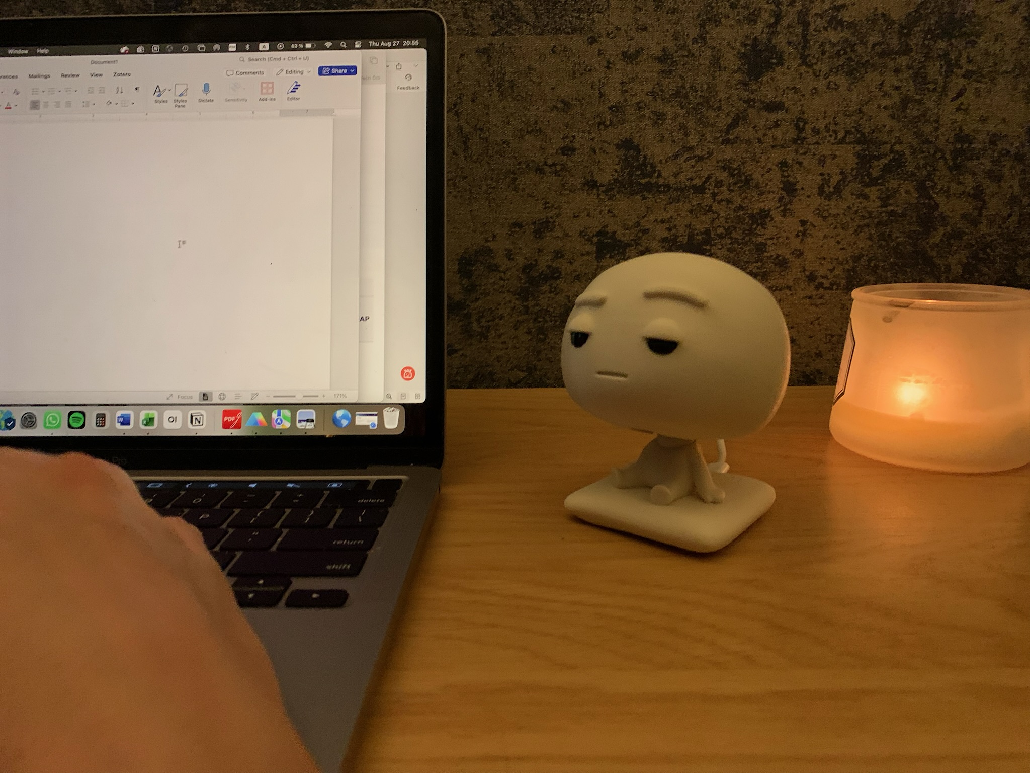 Pixl Nub on a warm candlelit desk beside a laptop during a late-night work session