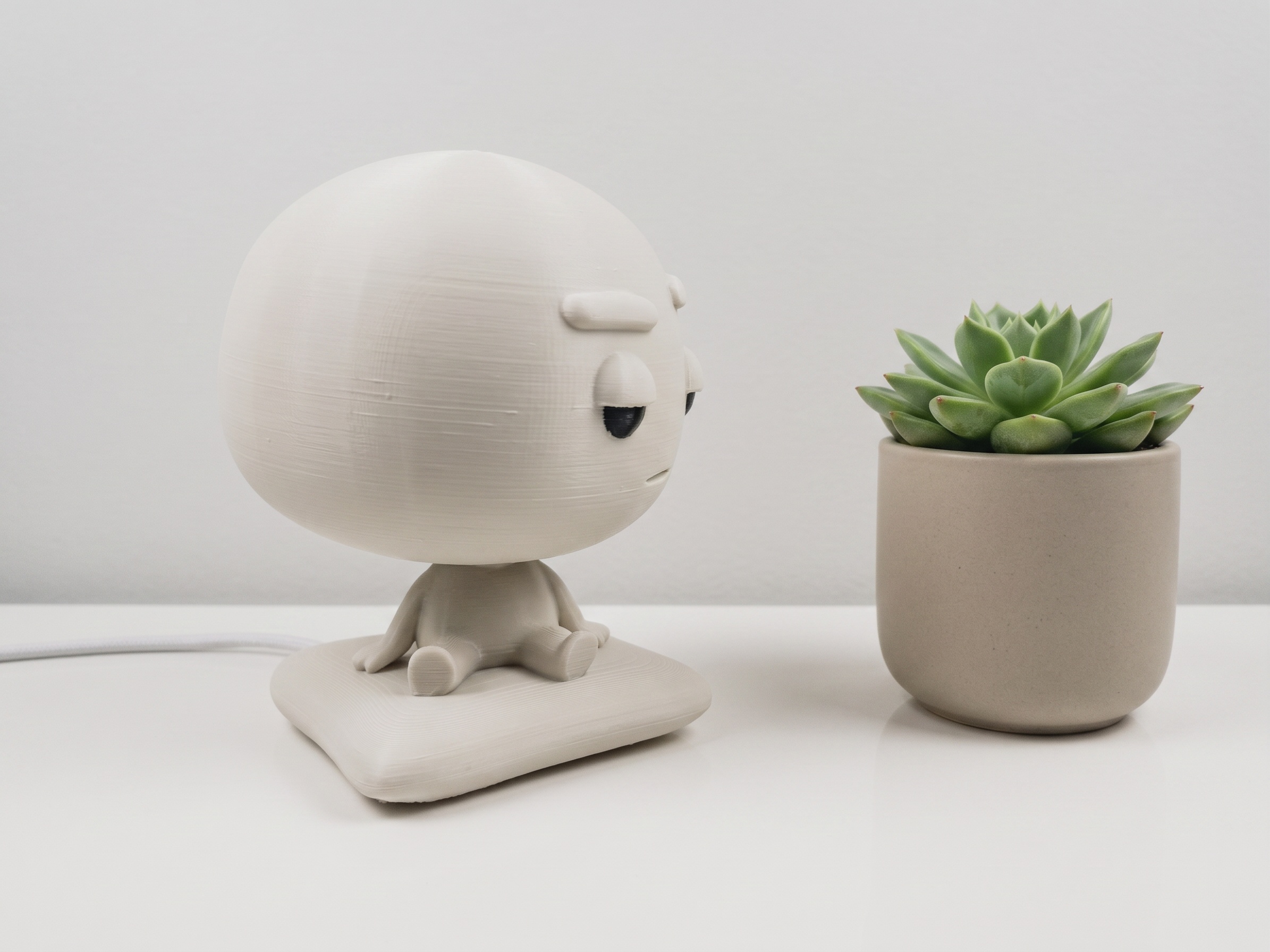Pixl Nub on a warm wooden desk with a plant
