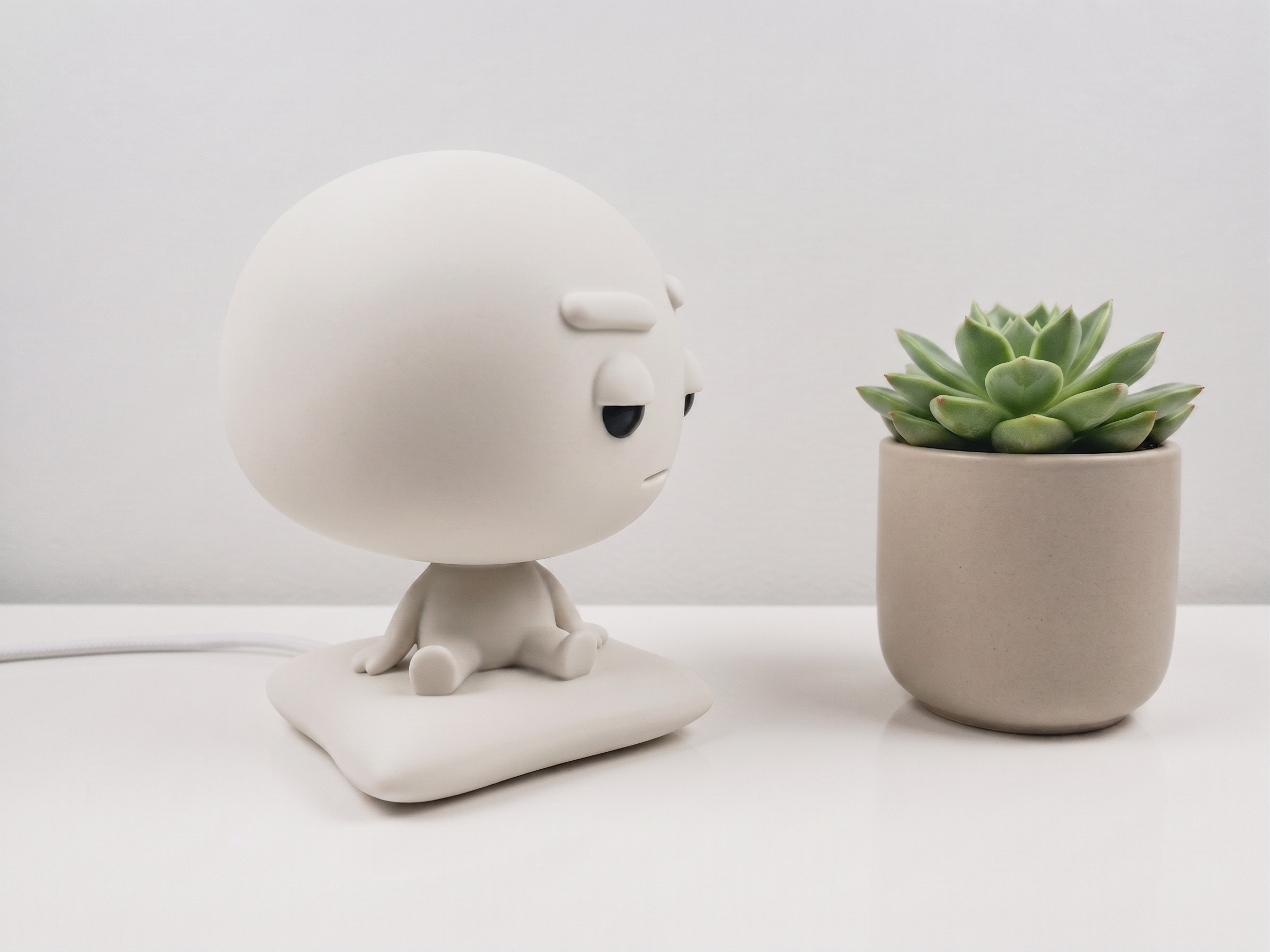 Pixl Nub on a desk beside a plant