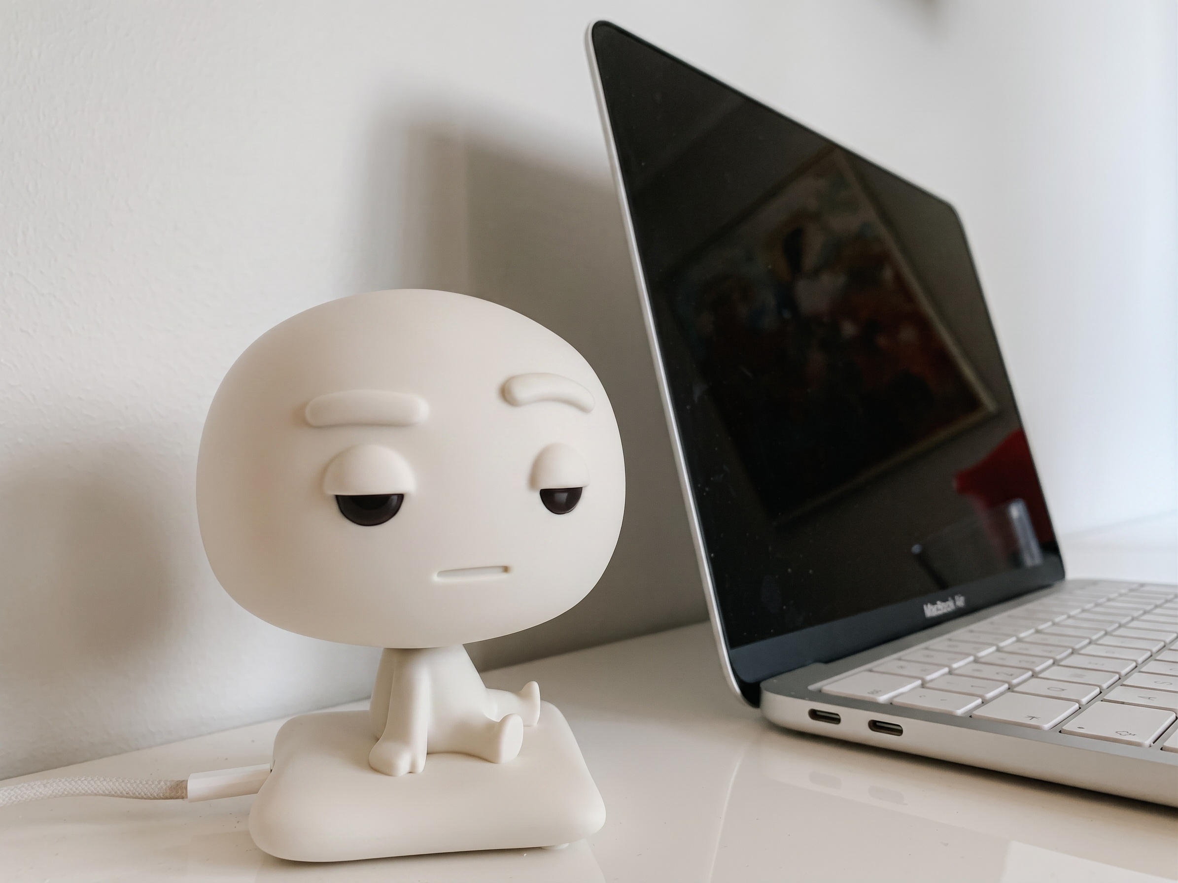 Pixl Nub on a clean white desk in front of a closed laptop