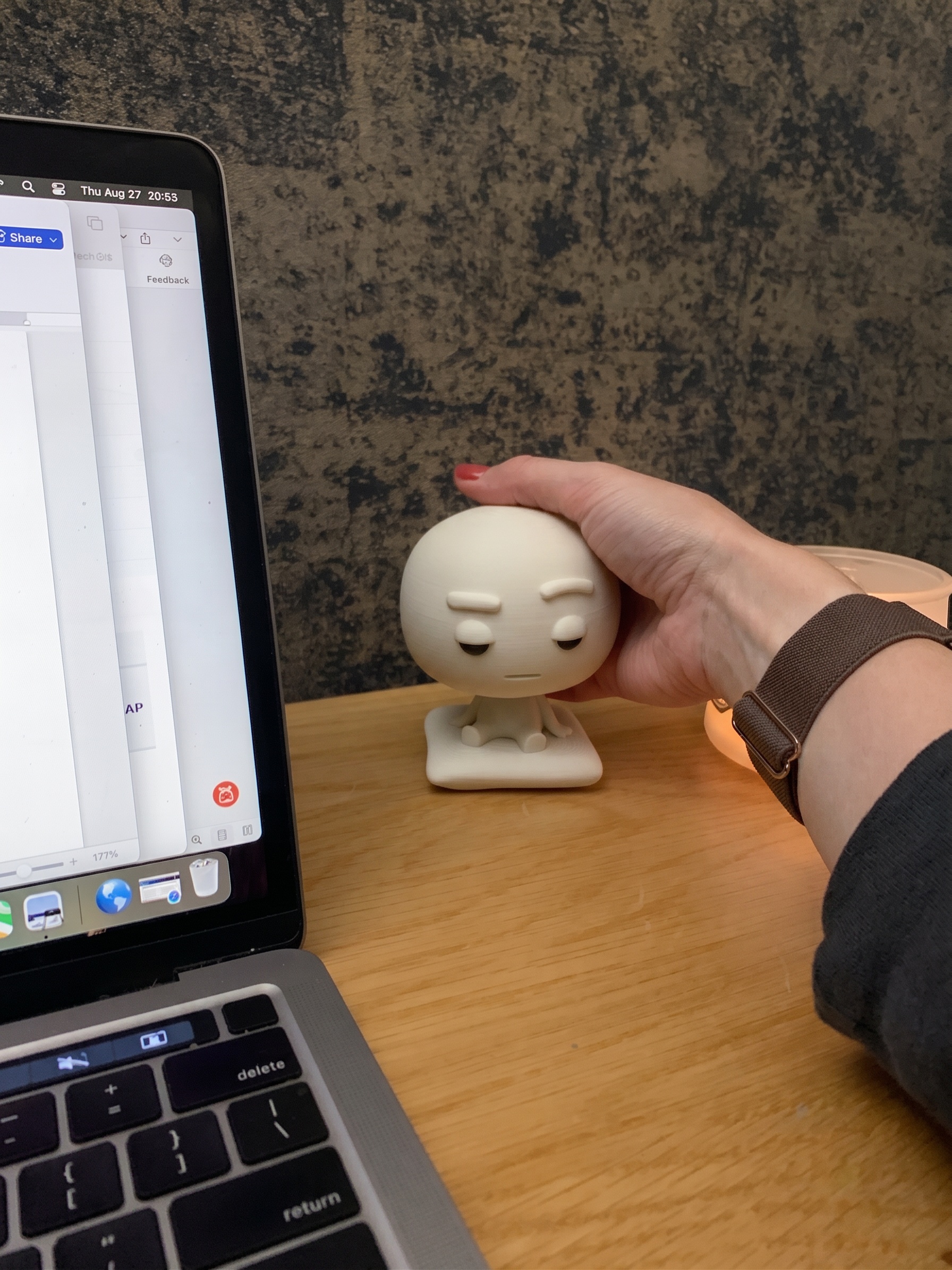 Pixl Nub on a wooden desk beside a laptop in a bright room